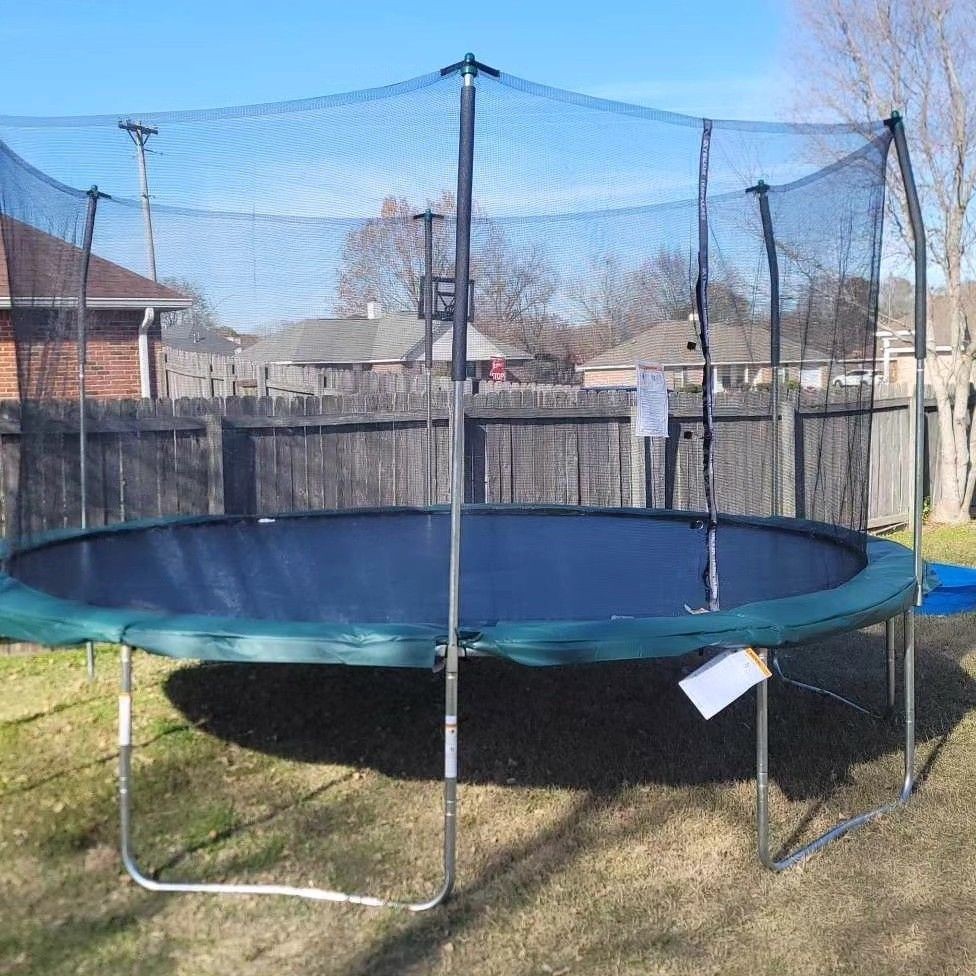 Round trampoline with safety net in a backyard on a sunny day.